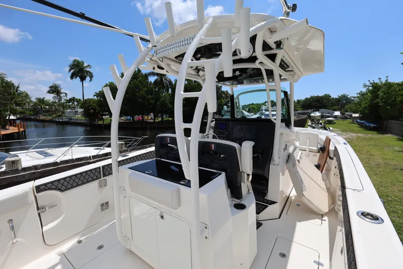 Slide: The Image of 2017 Wellcraft Scarab 302 Fisherman boat interior with helm and seating, docked by a canal. - 10