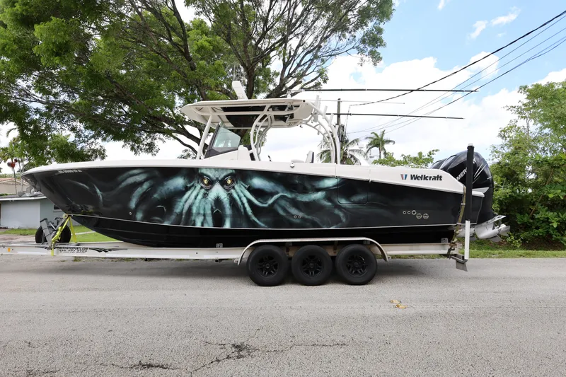 Slide: The Image of 2017 Wellcraft Scarab 302 Fisherman boat with octopus-themed hull design on a trailer. - 2