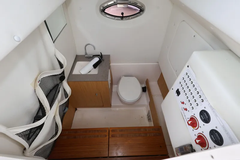 Slide: The Image of Interior of 2017 Wellcraft Scarab 302 Fisherman boat, featuring a compact bathroom with sink and toilet. - 23