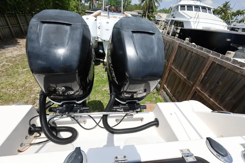 Slide: The Image of 2017 Wellcraft Scarab 302 Fisherman with dual outboard engines, docked near a wooden fence. - 27