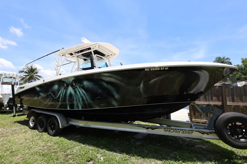Slide: The Image of 2017 Wellcraft Scarab 302 Fisherman boat on trailer, parked outdoors under blue sky. - 28