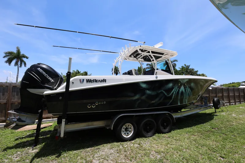 Slide: The Image of 2017 Wellcraft Scarab 302 Fisherman boat on trailer, featuring dual Mercury engines. - 29