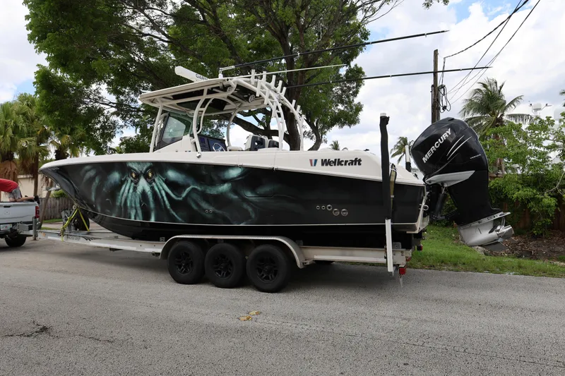 Slide: The Image of 2017 Wellcraft Scarab 302 Fisherman boat on trailer, featuring striking marine graphics. - 3