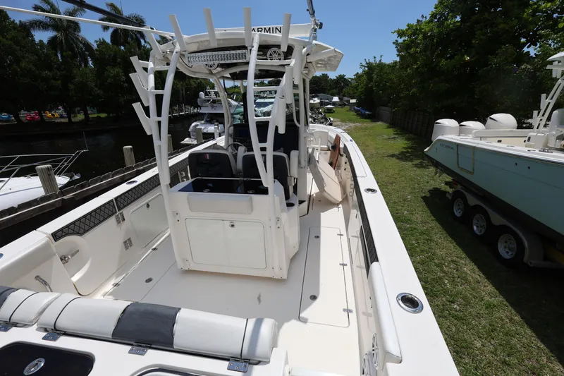 Slide: The Image of 2017 Wellcraft Scarab 302 Fisherman boat with center console and seating, docked near greenery. - 9