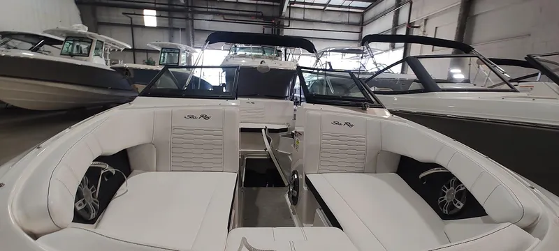 Slide: The Image of 2023 Sea Ray SPX 190 boat interior with white seating in a showroom. - 20