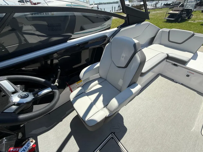 Slide: The Image of 2022 Yamaha Boats AR250 interior with sleek seating and modern steering wheel. - 11