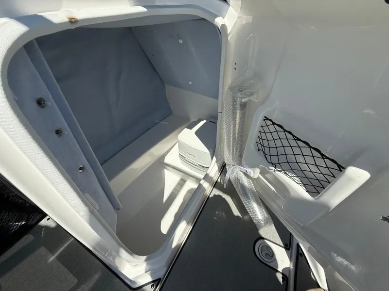 Slide: The Image of 2022 Yamaha AR250 boat storage compartment with netted pocket and clean interior design. - 16