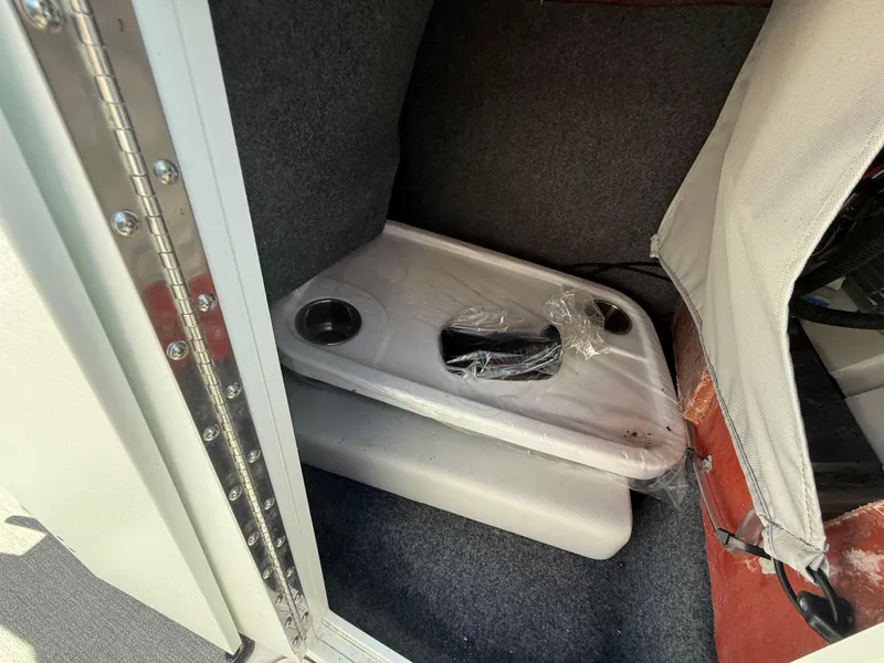 Slide: The Image of 2022 Yamaha Boats AR250 interior storage with table and cup holders. - 17