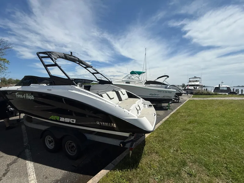 Slide: The Image of 2022 Yamaha AR250 boat on trailer, parked near marina under blue sky. - 5