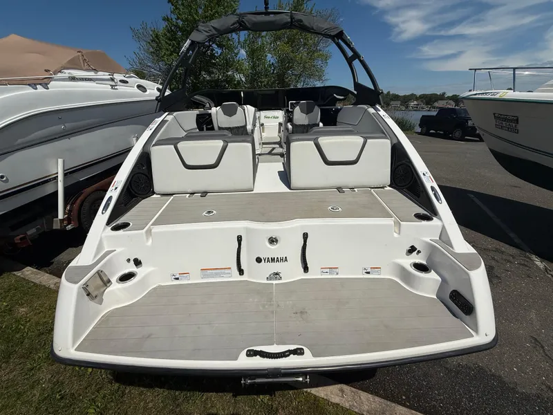 Slide: The Image of 2022 Yamaha AR250 boat, rear view, docked with seating and swim platform visible. - 7