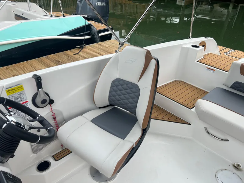 Slide: The Image of 2025 Starcraft SVX 211 OB boat interior with cushioned seating and steering wheel. - 17