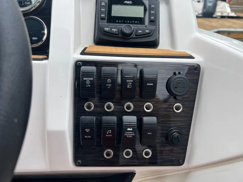 Slide: The Image of Control panel of 2025 Starcraft SVX 211 OB boat with switches and radio. - 9