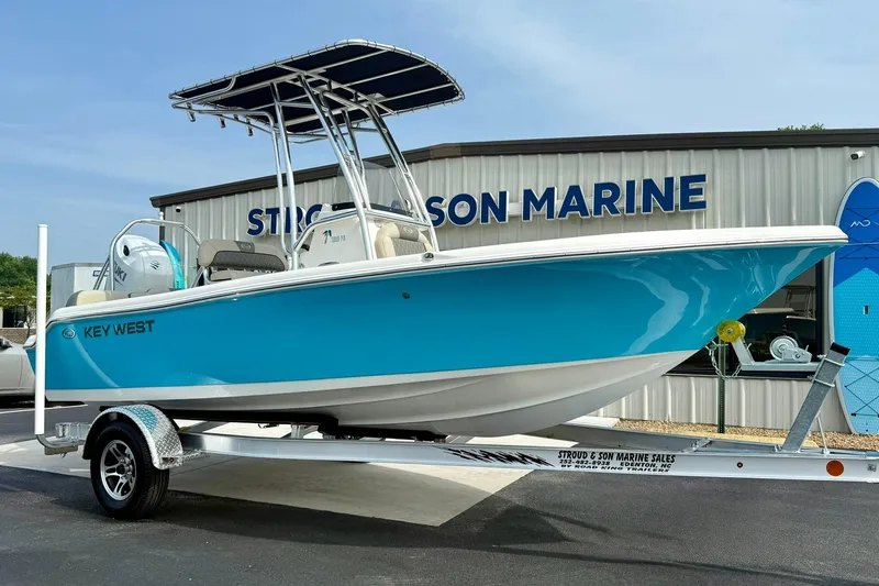 Slide: The Image of 2025 Key West 189 FS boat in blue on a trailer, displayed at a marine dealership. - 4