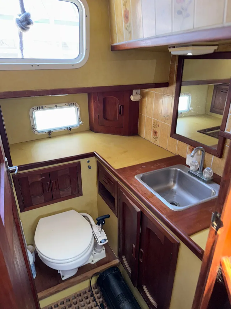 Slide: The Image of 1980 Cooper Marine Mapleleaf 48 yacht bathroom with sink, toilet, and wooden cabinetry. - 17
