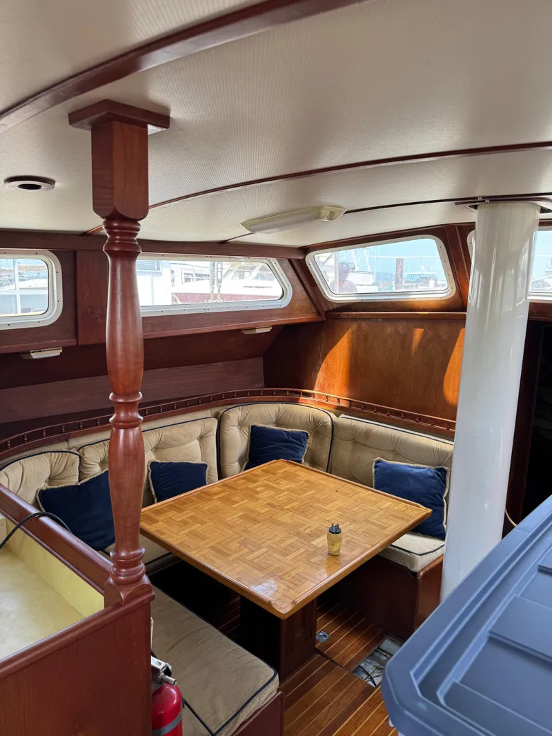 Slide: The Image of Interior of 1980 Cooper Marine Mapleleaf 48 yacht with wooden dining area and cushioned seating. - 2