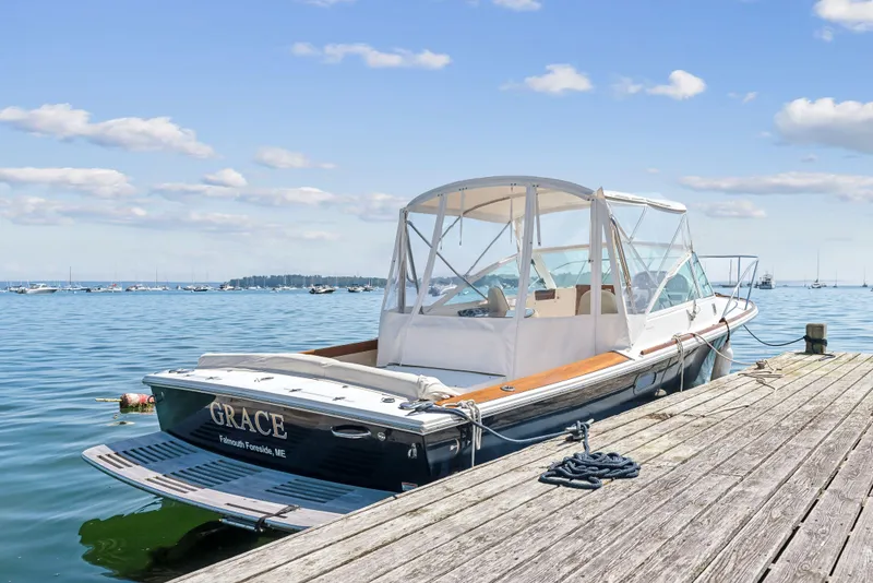 Slide: The Image of 2015 Hunt Yachts 25 Harrier docked by the sea under a clear blue sky. - 16