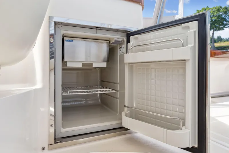 Slide: The Image of Open mini fridge on 2015 Hunt Yachts 25 Harrier, showcasing interior storage space. - 47