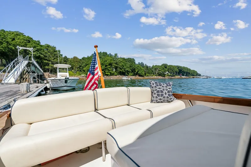Slide: The Image of 2015 Hunt Yachts 25 Harrier with American flag, docked by scenic shoreline. - 48