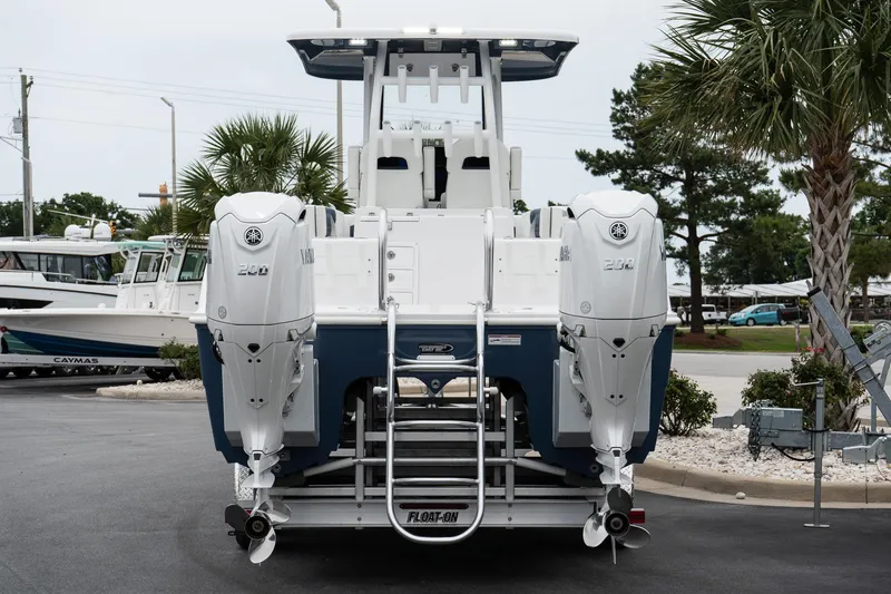 Slide: The Image of 2025 Twin Vee 260 GFX2 CC boat with dual outboard engines, docked in a marina. - 10
