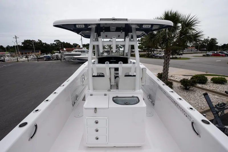 Slide: The Image of 2025 Twin Vee 260 GFX2 CC boat, center console, docked with palm tree in background. - 12