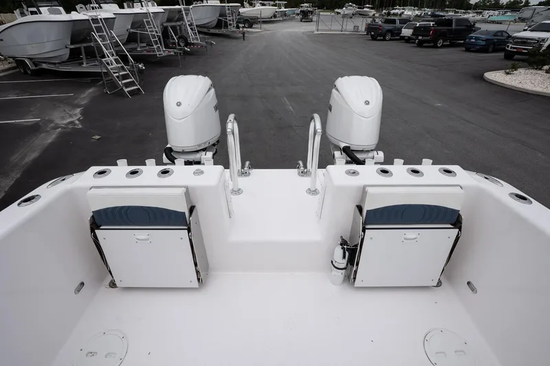 Slide: The Image of 2025 Twin Vee 260 GFX2 CC boat with dual engines, docked in a marina. - 13