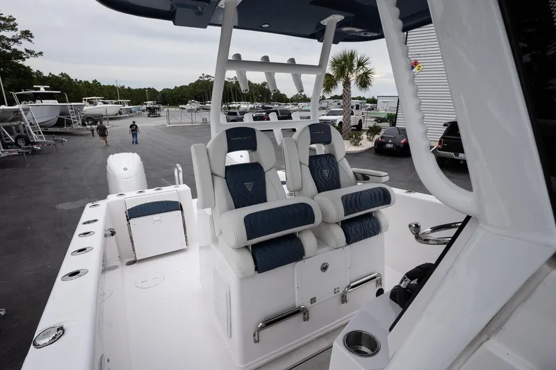 Slide: The Image of 2025 Twin Vee 260 GFX2 CC boat with luxurious seating in a marina setting. - 15