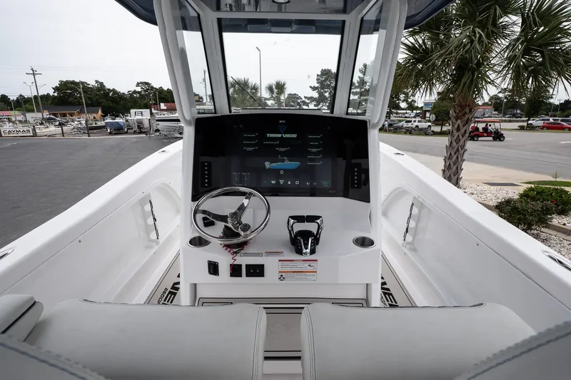 Slide: The Image of 2025 Twin Vee 260 GFX2 CC boat dashboard with steering wheel and digital display. - 17