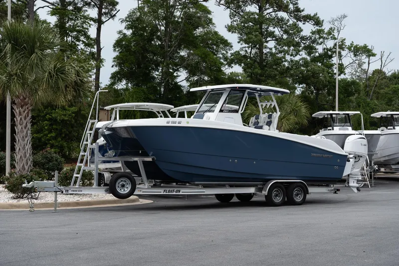 Slide: The Image of 2025 Twin Vee 260 GFX2 CC boat on trailer, parked outdoors. - 2