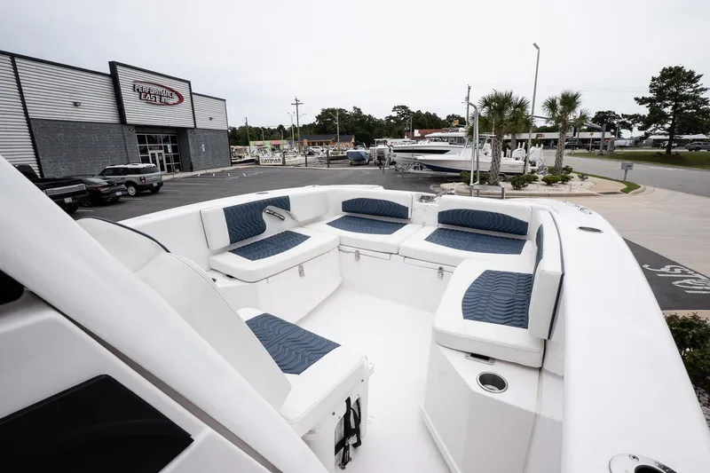 Slide: The Image of 2025 Twin Vee 260 GFX2 CC boat with spacious seating, displayed at a dealership. - 23