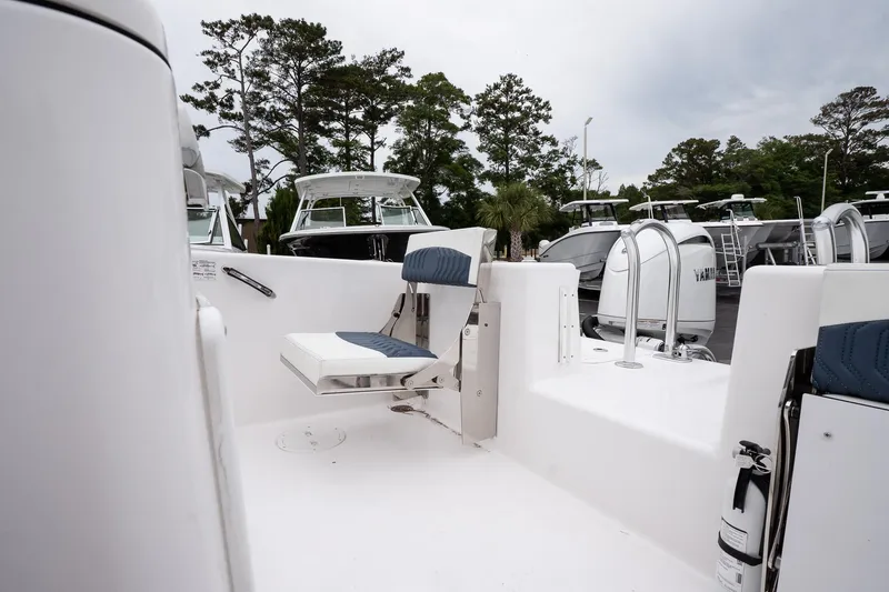 Slide: The Image of 2025 Twin Vee 260 GFX2 CC boat interior with seating and ladder, surrounded by trees. - 26