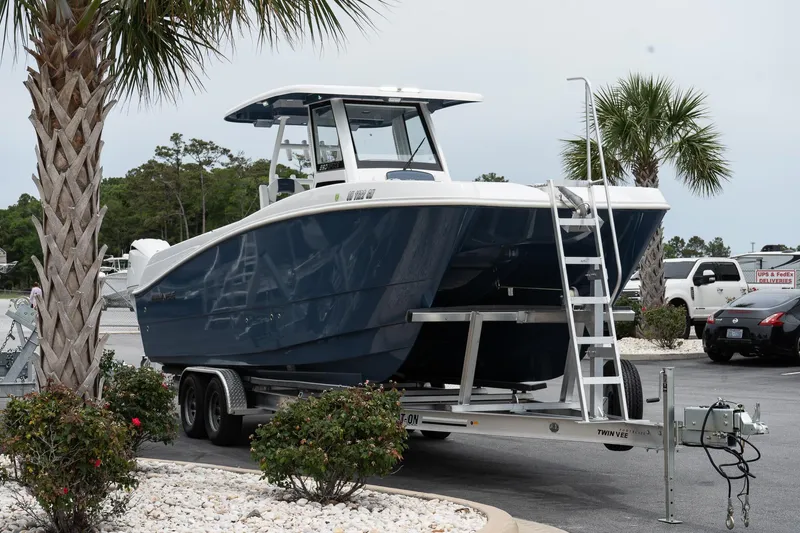 Slide: The Image of 2025 Twin Vee 260 GFX2 CC boat on trailer, parked near palm trees. - 6