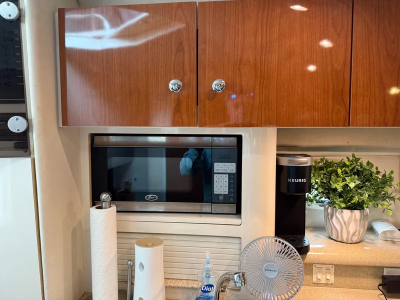 Slide: The Image of Kitchen area of a 2001 Monterey 322 Cruiser with microwave, cabinets, and countertop accessories. - 16