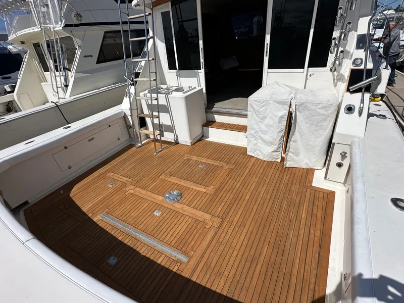 Slide: The Image of 1978 Bertram 46 Convertible yacht with teak deck and ladder, docked at marina. - 14