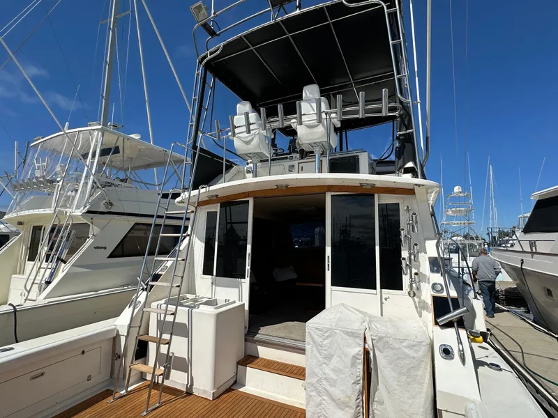 Slide: The Image of 1978 Bertram 46 Convertible yacht docked at marina, featuring spacious deck and flybridge. - 15