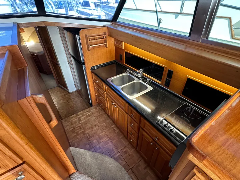 Slide: The Image of 1978 Bertram 46 Convertible yacht kitchen with wood cabinetry and modern appliances. - 19