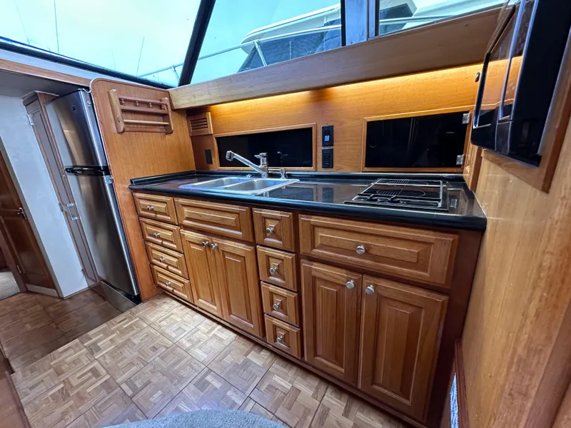 Slide: The Image of 1978 Bertram 46 Convertible yacht kitchen with wooden cabinets and modern appliances. - 20