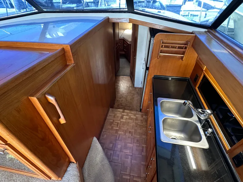 Slide: The Image of 1978 Bertram 46 Convertible yacht interior with wooden cabinetry and dual sink kitchen area. - 21