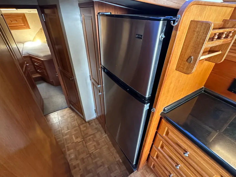 Slide: The Image of 1978 Bertram 46 Convertible yacht interior with wood cabinetry and stainless steel refrigerator. - 23