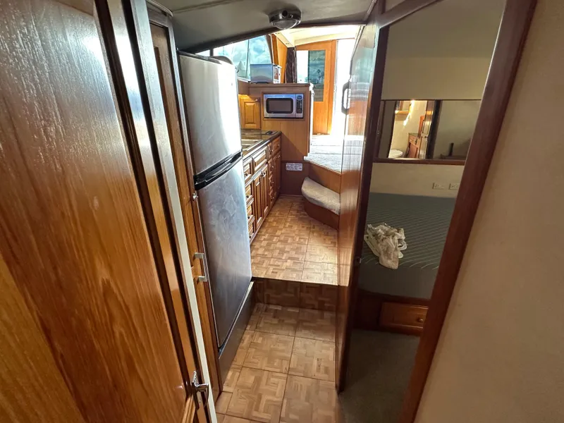 Slide: The Image of 1978 Bertram 46 Convertible interior with kitchen, wood cabinetry, and compact appliances. - 24