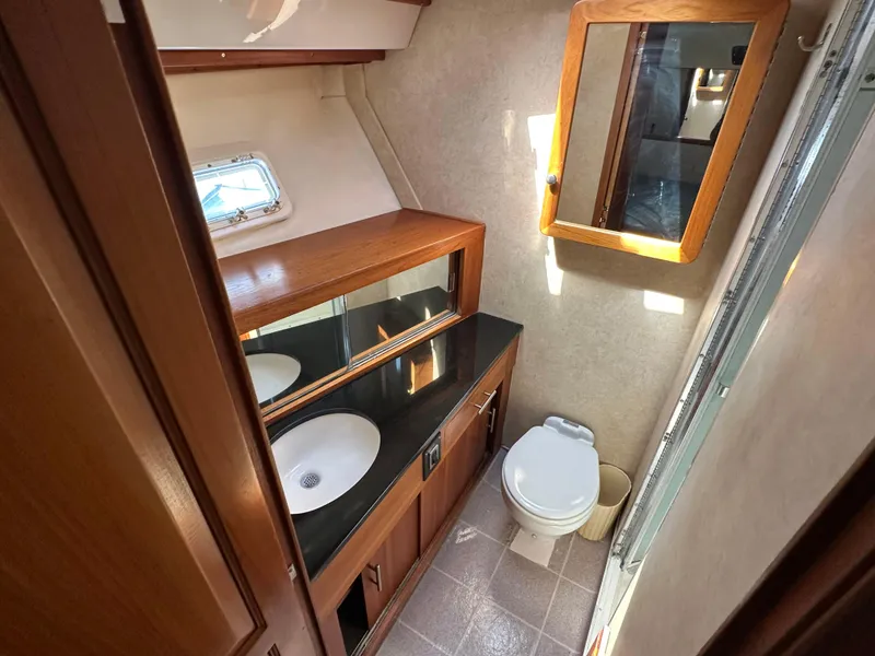 Slide: The Image of 1978 Bertram 46 Convertible yacht bathroom with sink, mirror, and toilet. - 26