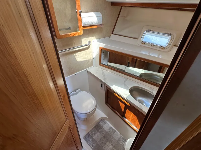 Slide: The Image of 1978 Bertram 46 Convertible yacht bathroom with toilet, sink, mirror, and window. - 28