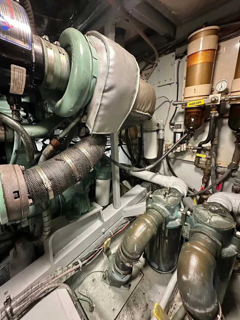 Slide: The Image of Engine room of a 1978 Bertram 46 Convertible boat, showcasing mechanical components and piping. - 35