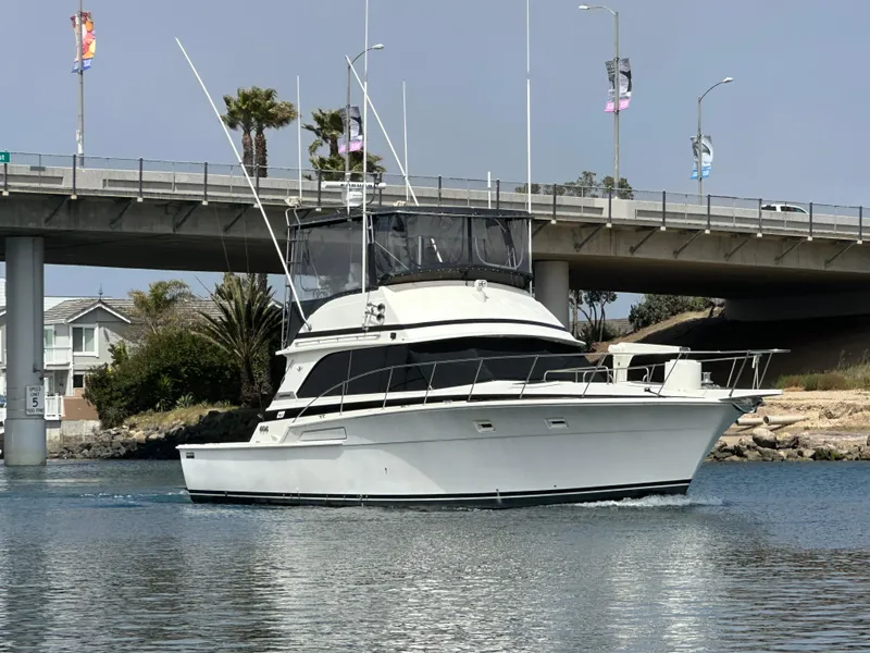 Slide: The Image of 1978 Bertram 46 Convertible yacht cruising under a bridge on a sunny day. - 4