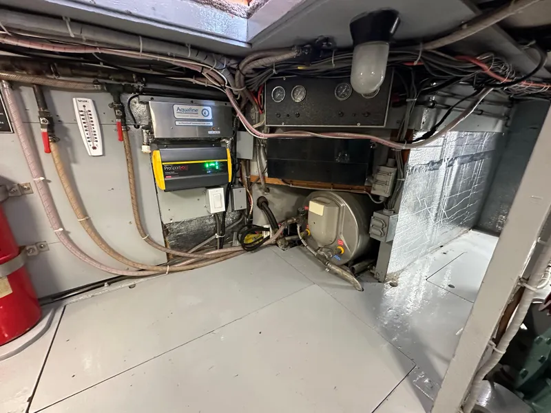 Slide: The Image of Engine room of a 1978 Bertram 46 Convertible boat, showcasing wiring and equipment. - 40