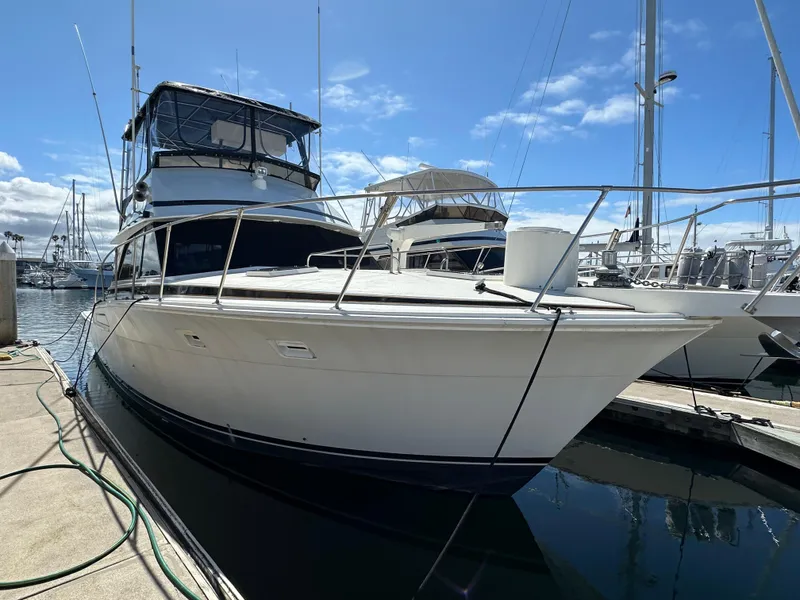 Slide: The Image of 1978 Bertram 46 Convertible yacht docked at marina under clear blue sky. - 8