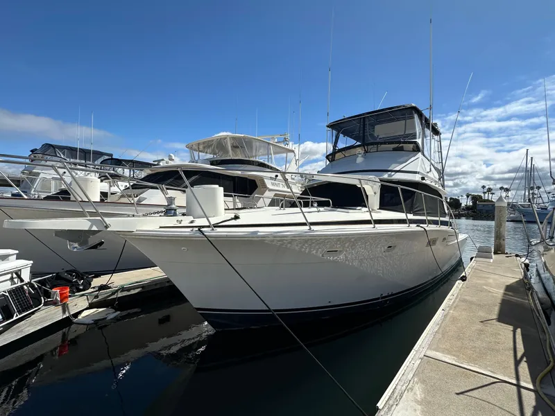 Slide: The Image of 1978 Bertram 46 Convertible yacht docked at marina under clear blue sky. - 9