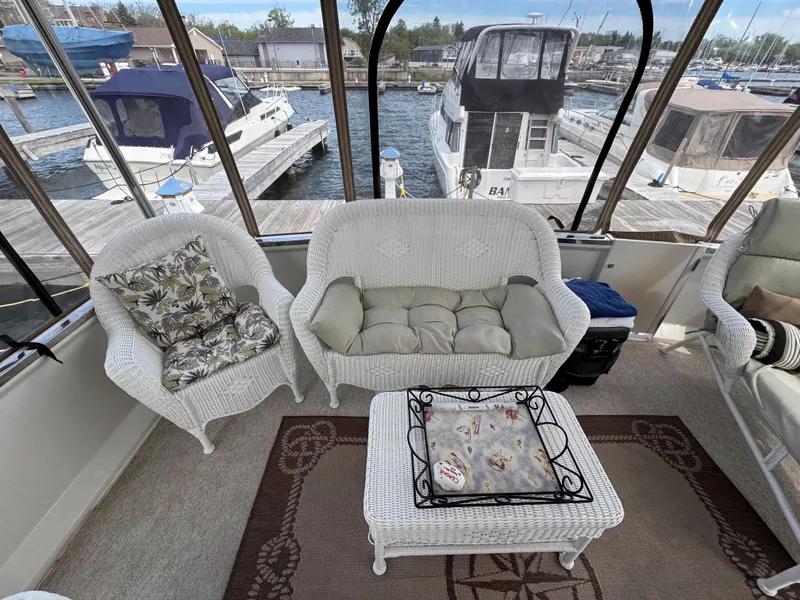 Slide: The Image of 1999 Carver 406 Aft Cabin Motor Yacht interior with wicker seating and marina view. - 10
