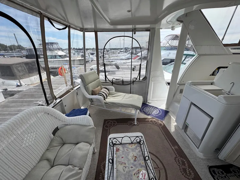 Slide: The Image of 1999 Carver 406 Aft Cabin Motor Yacht interior with comfortable seating and marina view. - 11