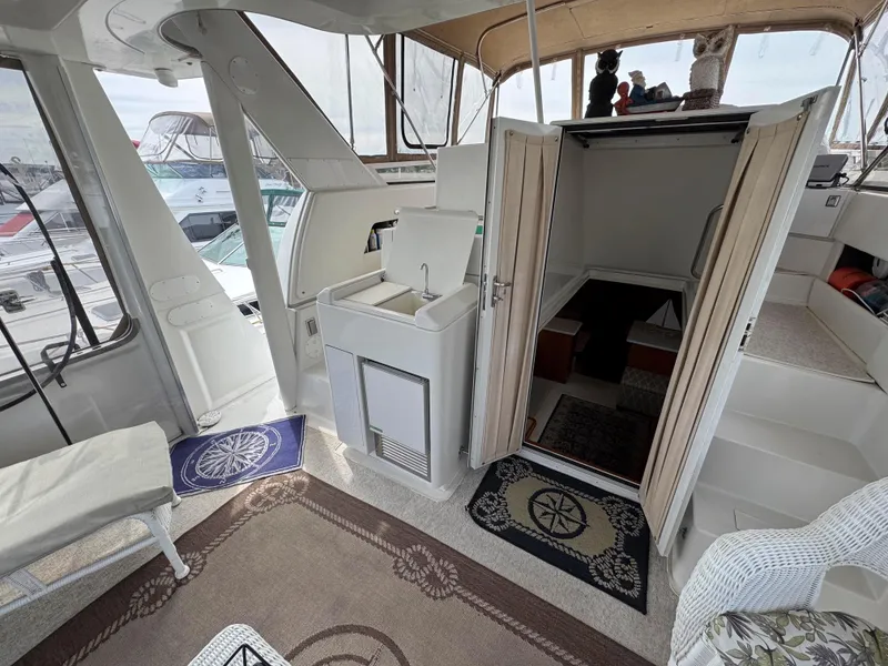 Slide: The Image of 1999 Carver 406 Aft Cabin Motor Yacht interior with seating, sink, and cabin entrance. - 12