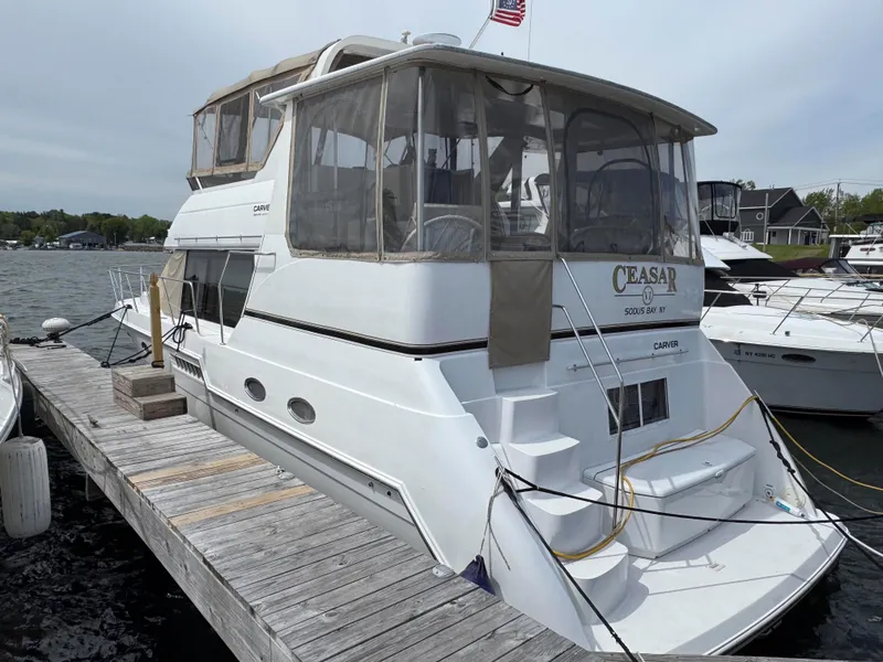 Slide: The Image of 1999 Carver 406 Aft Cabin Motor Yacht docked at marina, rear view. - 2